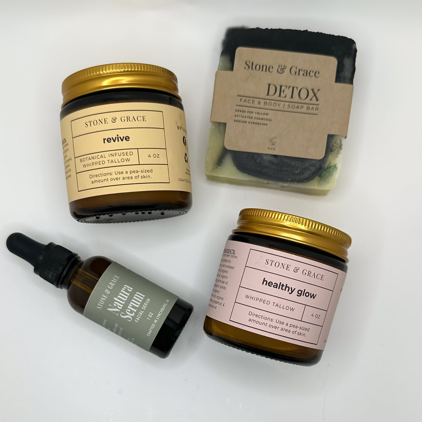 Collection of Stone & Grace skincare products including a serum, jar, and soap bar on a white background.