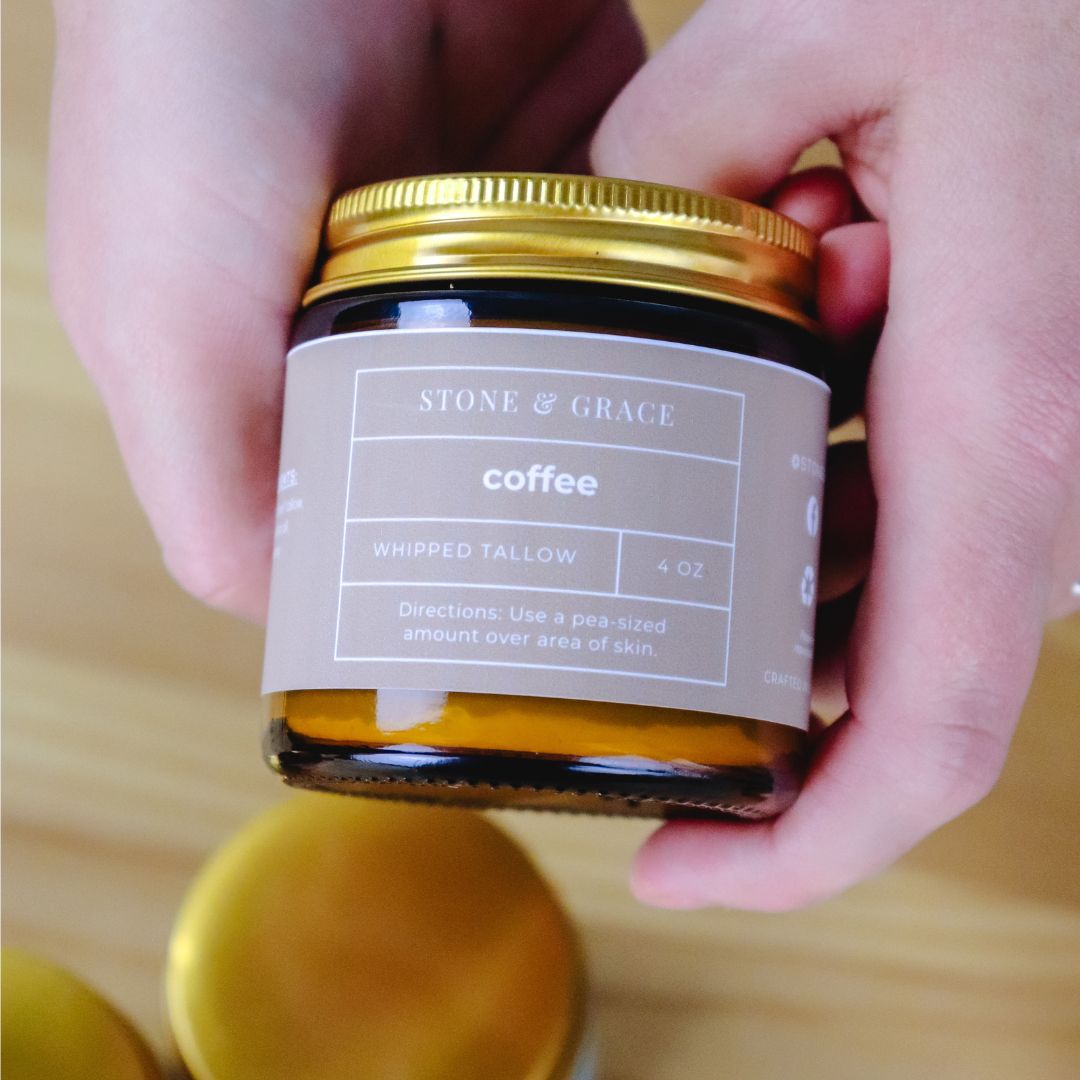 Jar of 'Stone & Grace' coffee whipped tallow on a wooden surface