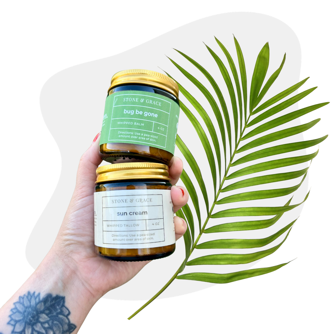 Hand holding two jars of Stone & Grace skincare products with a green leaf on a white background