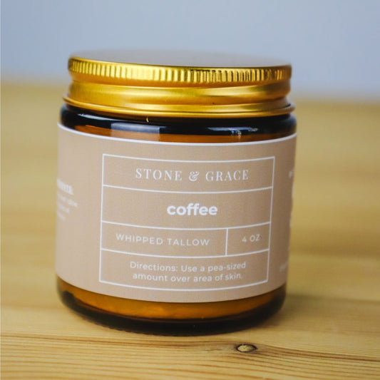 Jar of 'Coffee' whipped tallow from Stone & Grace on a wooden surface with a light gray background