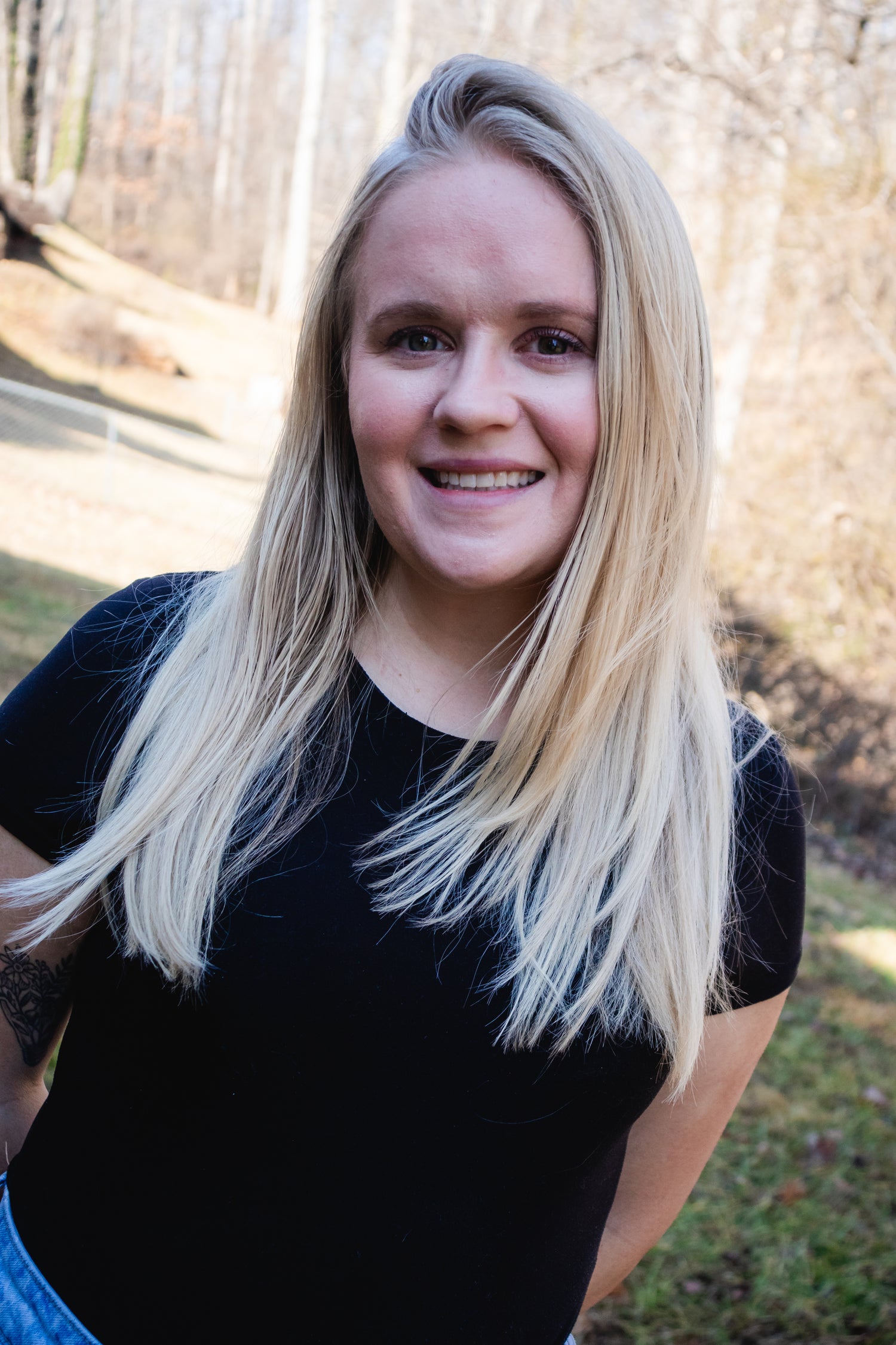 Woman with long blonde hair wearing a black shirt outdoors