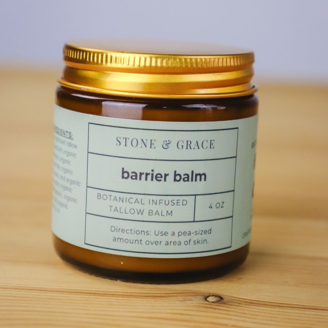 Brown jar with a gold-toned lid of Stone & Grace barrier balm on a wooden surface